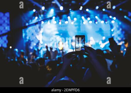 Hand mit dem Smartphone eingeschaltet, um aufzunehmen oder Bilder während des Live-Konzerts. Stockfoto