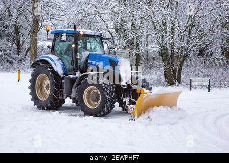 Traktor mit Schneepflug oder Pflug, der die Straße freilegt, Lymington Bottom Road, Medstead, Alton, Hampshire, England, Vereinigtes Königreich. Stockfoto