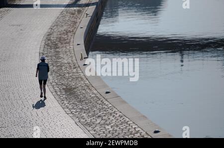 Berlin, Deutschland. März 2021, 03rd. Ein Jogger läuft entlang der Spree im Regierungsbezirk. Quelle: Paul Zinken/dpa-Zentralbild/dpa/Alamy Live News Stockfoto