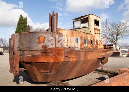 Ein rostiges Boot, das neben dem Coventry Kanal in der Nähe von Alvecote Marina, Tamworth, Staffordshire, abgebildet ist. Stockfoto