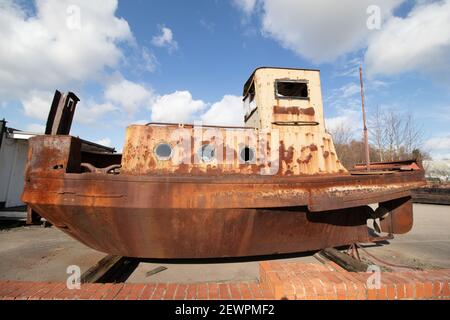 Ein rostiges Boot, das neben dem Coventry Kanal in der Nähe von Alvecote Marina, Tamworth, Staffordshire, abgebildet ist. Stockfoto