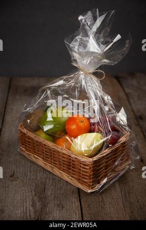 Obstkorb einzeln verpackt. Lieferung von Produkten. Essen auf Bestellung. Eine Reihe von verschiedenen Früchten. Vitamingeschenk. Zellophan-Verpackung während des Quarants Stockfoto