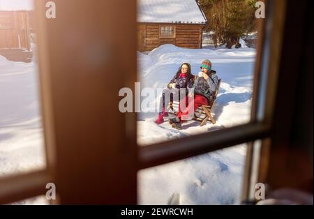 Pärchen genießen den Wintertag mit einer Tasse Heißgetränk Holzhaus Stockfoto