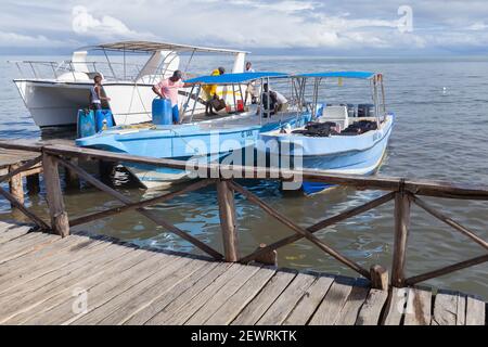 Samana, Dominikanische republik - 7. Januar 2020: Samana Bay Coast, Crew bereiten Motorboote für Ausflüge Stockfoto