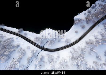 Autos auf verschneiten Straßen am Ufer des Sils von oben, Engadin, Kanton Graubünden, Schweiz, Europa Stockfoto