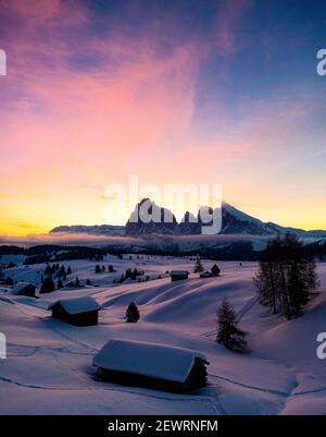 Schneebedeckte Berghütten bei Sonnenaufgang mit Langkofel und Langkofel im Hintergrund, Seiser Alm, Dolomiten, Südtirol, Italien, Europa Stockfoto