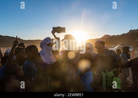 Hintergrundbeleuchtung einer Menge von Kindern und Tuareg Männer, Oase von Timia, Air Mountains, Niger, Afrika Stockfoto