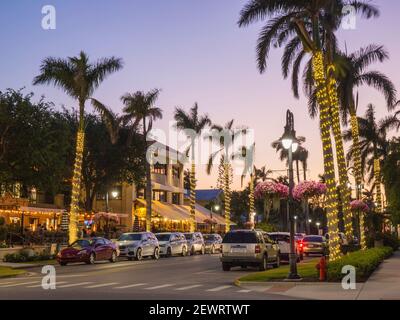 Blick auf die palmengesäumte 13th Avenue South im Herzen des besten Restaurants der Stadt, Dusk, Naples, Florida, USA Stockfoto