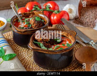 Veganes Fleischgericht mit Linsennussfleischbällchen und würziger arabischer Tomatensuppe gewürzt mit Curry, Kreuzkümmel, Kurkuma und garniert mit Kokosmilch Stockfoto