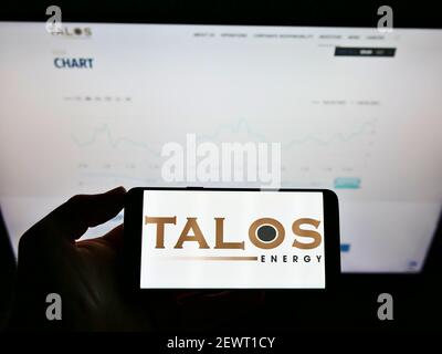 Person mit Mobiltelefon und Firmenlogo des US-amerikanischen Öl- und Gasunternehmens Talos Energy Inc. Auf dem Bildschirm vor der Website. Fokus auf Handy-Display. Stockfoto