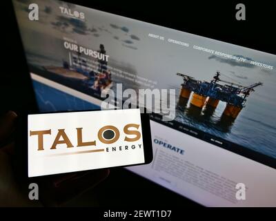 Person, die Smartphone mit dem Logo des US-Öl- und Gasunternehmens Talos Energy Inc. Auf dem Bildschirm vor der Website hält. Konzentrieren Sie sich auf die Telefonanzeige. Stockfoto
