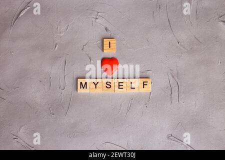 Holzblock Buchstaben geschrieben Phrase Ich liebe mich auf grauem Hintergrund. Konzept psychische Gesundheit Journaling, gesunde Denkweise, mich selbst akzeptieren. Stockfoto