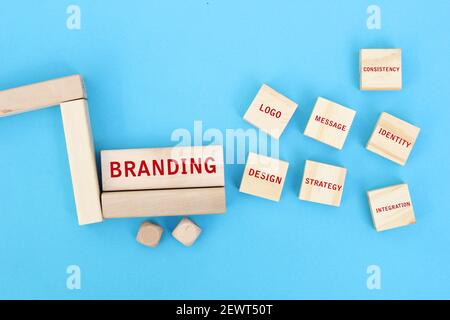 Das Konzept des Brandings und seine wesentlichen Elemente auf Holzblöcken auf blauem Hintergrund geschrieben. Konzept des Produkt- oder Dienstleistungsmarkenings im Geschäft. Stockfoto