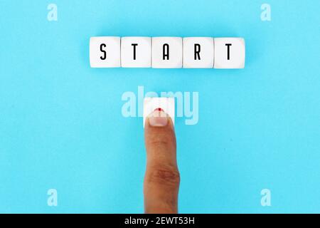 Das Wort Start auf Würfel mit einer männlichen Hand drücken Sie die Start-Taste. Einen neuen Start in das Leben, Wirtschaft, Bildung oder Karriere Konzept zu machen. Stockfoto