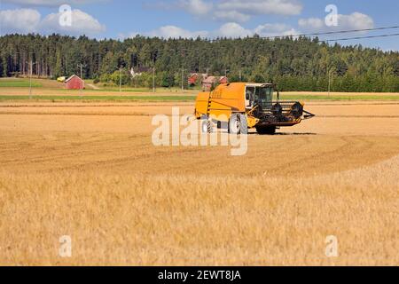 Landwirtschaftliche Landschaft mit Gelb kombinieren auf teilweise geerntetem Getreidefeld an einem schönen Herbsttag. Platz kopieren, keine Personen, Branding entfernt. Stockfoto