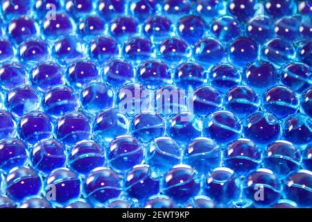 Wasserblaue Gelbälle. Polymergel. Kieselgel. Kugeln aus blauem Hydrogel. Kristall flüssige Kugel mit Reflexion. Texturhintergrund. Nahaufnahme Makro Stockfoto