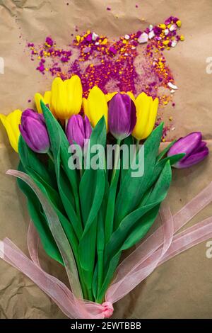 Bouquet von gelben und violetten Tulpen im Aquarellstaub Auf dem Tisch des Malers Stockfoto