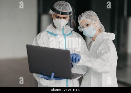 Männer in speziellen Virus Schutzanzüge, die Forschung der Coronavirus Verfügbarkeit auf öffentlichen Parkplätzen, covid 2019, Epidemie Stockfoto