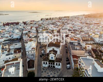 Luftaufnahme von Olhao mit einer Kirche im Vordergrund bei Sonnenuntergang, Algarve, Portugal Stockfoto