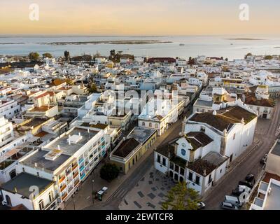 Luftaufnahme von Olhao mit einer Kirche im Vordergrund bei Sonnenuntergang, Algarve, Portugal Stockfoto