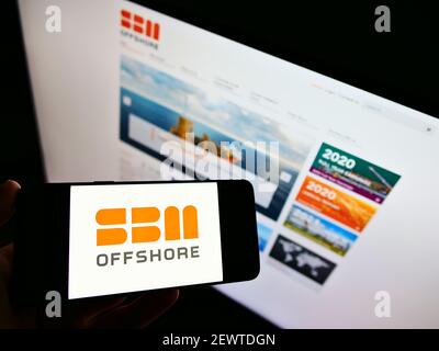 Person hält Smartphone mit Logo der niederländischen Öl-und Gasunternehmen SBM Offshore N.V. auf dem Bildschirm vor der Website. Konzentrieren Sie sich auf die Telefonanzeige. Stockfoto