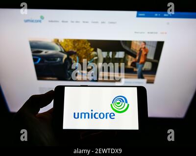 Person hält Smartphone mit Logo der belgischen Materialien und Recycling-Unternehmen Umicore N.V. auf dem Bildschirm vor der Website. Konzentrieren Sie sich auf die Telefonanzeige. Stockfoto