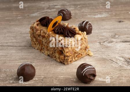 Elegantes und appetitliches Stück Kuchen neben Schokoladenkugeln, Gebäck in einem Studio Stockfoto