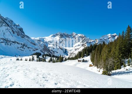 Winterwunderland im Bregenzerwald, Körbersee mit Mohnenfluh und den verschneiten Bergen ringsum. Wälder und Almwiesen im Skigebiet salober Stockfoto