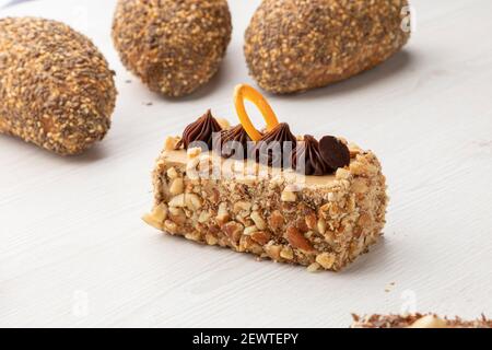 Kuchen gefüllt und dekoriert mit Schokolade neben Vollkornbrot mit Samen und Sesam auf, Gebäck in einem Studio Stockfoto
