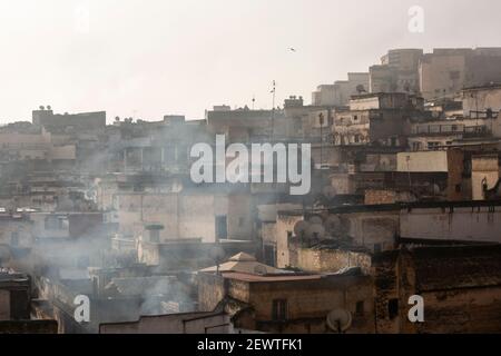 Rauch steigt über die Dächer der Fes Medina am frühen Morgen, Fes, Marokko Stockfoto