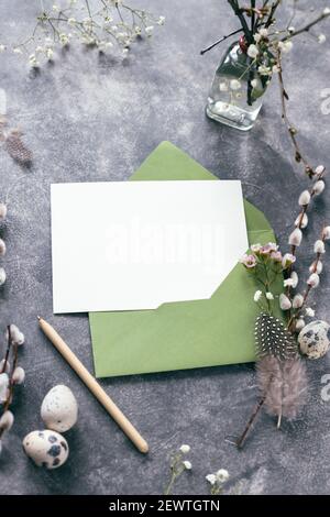 Leere Karte auf Ostern verzierten Tisch mit Weidenzweigen. Modell, Winkelansicht. Stockfoto