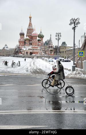 = Reiten von Vintage-Fahrrädern am Basil-Hang = Vater und Sohn fahren auf Vintage-Fahrrädern am Kremlin-Ufer im Hintergrund der Basilius-Kathedrale Stockfoto