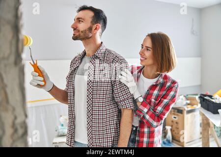 Erfreut junge Frau bewundernd ihren Mann Arbeit Stockfoto