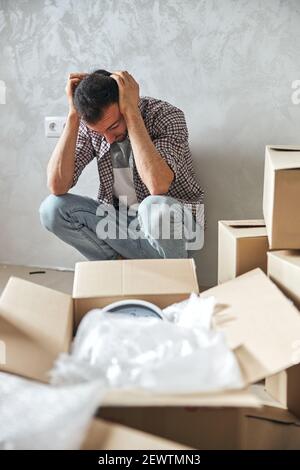 Junger Mann beschäftigt mit einem Umzug in eine neue Wohnung Stockfoto