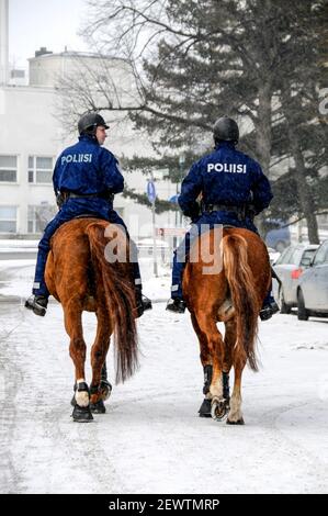 Zwei finnische Polizisten reiten auf ihren Pferden in der Nähe eines Stadtparks in Helsinki, Finnland Stockfoto