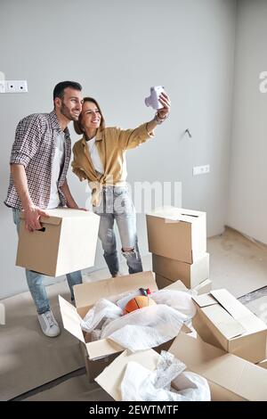Paar posiert für die Sofortkamera in einer neuen Wohnung Stockfoto