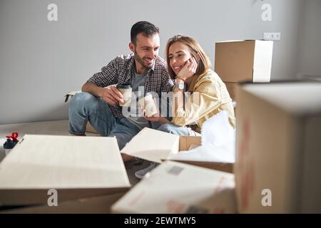 Ehepartner mit einer Kaffeepause beim Auspacken von Sachen Stockfoto