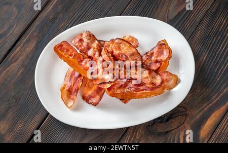 Gebratener Speck auf dem weißen Servierteller Stockfoto