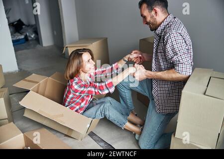 Mann hilft einer Frau zu den Füßen Stockfoto