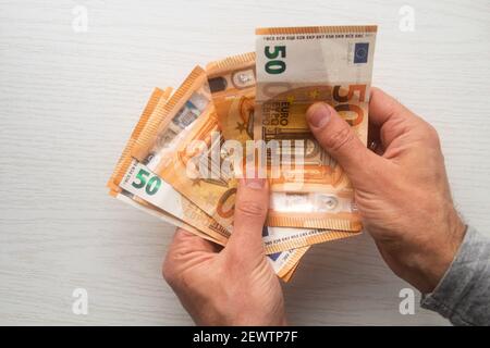Mann Hände zählen Euro-Bargeld Geldscheine auf weißem Tisch Stockfoto