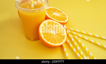 Orangensaft in geschlossener Fast Food-Tasse mit Schlauch Gelber Hintergrund Stockfoto