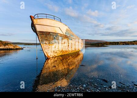 Abends fällt auf einem alten verfallenem Fischerboot in der Nähe des Dorfes Ahakista in Dunmanus Bay, West Cork, Irland auf dem Wild Atlantic Way Licht.