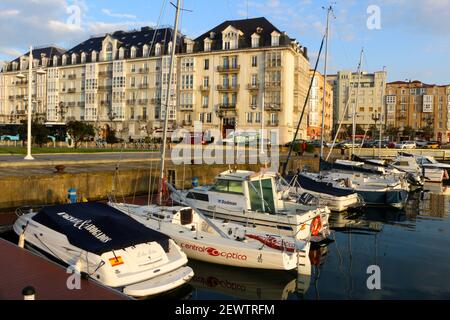 Am frühen Morgen Blick auf Motoryachten und Yachten in der marina in Santander Cantabria Spanien mit Verkehr entlang der Paseo De Pereda und Wohnblocks Stockfoto