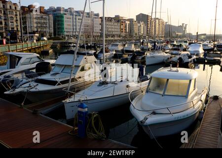 Am frühen Morgen sonnige Aussicht auf Motoryachten und Yachten in der Marina in Santander Cantabria Spanien mit Wohnblöcken hinter der Castelar Street Stockfoto