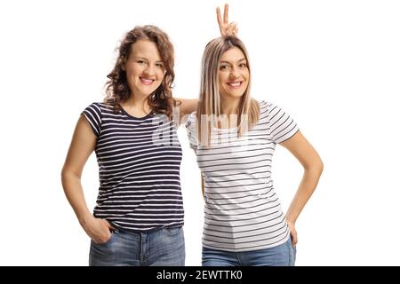 Weibliche Freunde posieren und machen Hasenohren auf dem Kopf isoliert Auf weißem Hintergrund Stockfoto