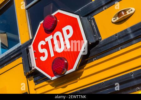 Stop-Schild auf einem ikonischen USA Schulbus Stockfoto