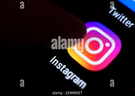 Madrid, Spanien - 3. März 2021: Finger drücken Instagram-Symbol auf schwarzem Handy-Bildschirm. Stockfoto