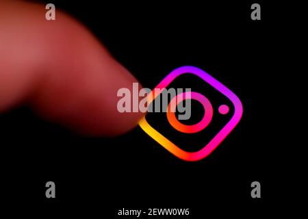 Madrid, Spanien - 3. März 2021: Finger drücken Instagram-Symbol auf schwarzem Handy-Bildschirm. Stockfoto