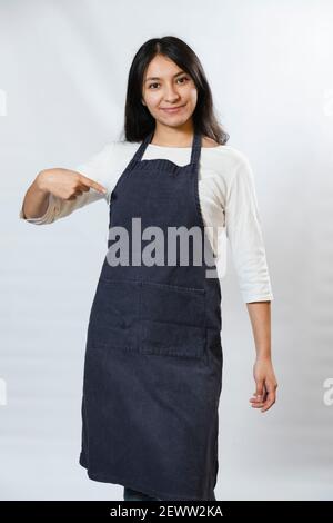 Hispanische Unternehmerin Frau mit blauen Schürze - fleißigt Frau zeigt Schürze Top zuversichtlich und glücklich - Young Cook Stockfoto