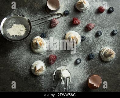 Flache Lay von Baiser, Eier Beeren und Zuckerpulver Stockfoto